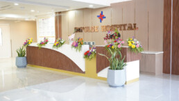 Modern hospital reception with floral arrangements.